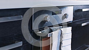 Close-up of white smoke coming out of a stainless steel electric oven. Stock footage. Modern kitchen appliances