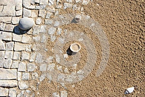 Close up of white stone slabs formed into a mosaic covered with beach sand and seashells. Broken tiles mosaic seamless pattern