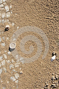 Close up of white stone slabs formed into a mosaic covered with beach sand and seashells. Broken tiles mosaic seamless pattern, re