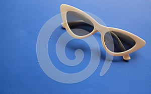 Close up white sunglasses isolate on a blue background