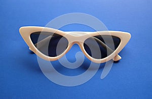 Close up white sunglasses isolate on a blue background