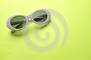 Close up  white sunglasses isolate on a green background