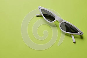 Close up  white sunglasses isolate on a green background