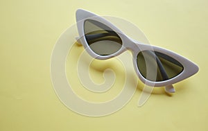 Close up  white sunglasses isolate on a yellow background