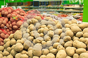 Close up of white and sweet potatoes on market stand.