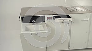 Close-up of white table and boxes for laboratory equipment in clean white room. Stock footage. Laboratory workspace