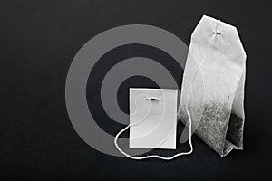 Close-up of white tea bag isolated on black background, mockup