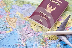 Close up the white toy airplane and passport on the world map ba