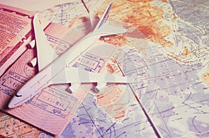 Close up the white toy airplane and passport on the world map background. Travel and business concept.toned