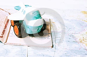 Close up the white toy airplane and passport on the world map background. Travel and business concept.toned