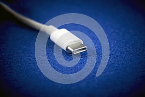 Close-Up of white USB Type-C cable on blue background.