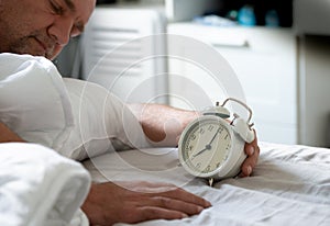 Close up the white vintage clock in the bedroom, the clock showing 7 o`clock  7 am  in the monring.