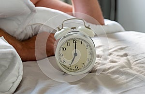 Close up the white vintage clock in the bedroom, the clock showing 7 o`clock  7 am  in the monring.