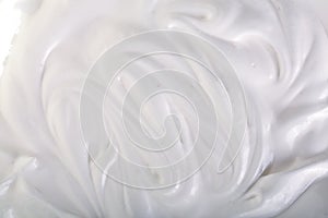 Close up of a white whipped or sour cream on white background