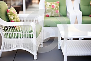 close-up of white wicker patio furniture with green cushions