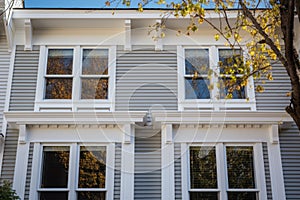 close-up of white window frames on a two-story colonialist house photo