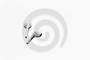 Close-up of white wireless earphones, isolated on background of white.