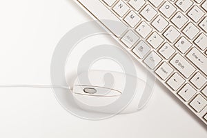 Close up of white wireless keyboard and wired mouse