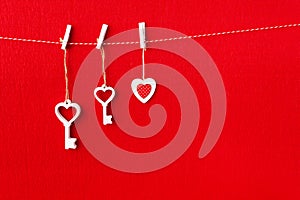 Close up of White wooden heart simbol and key on red paper background