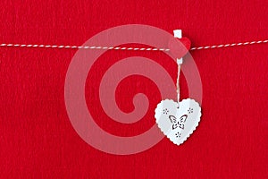 Close up of White wooden heart simbol on red paper background