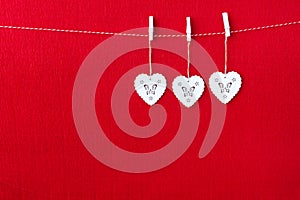 Close up of White wooden heart simbols on red paper background