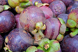 Close-up of whole mangosteen fruits on sale at a market stall