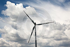 Close up of a wind power turbine vanes against beautiful clouds