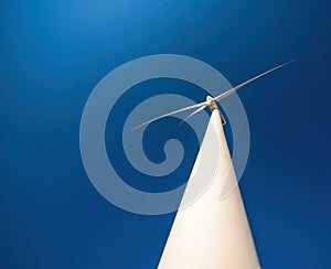 Close up of wind turbine against blue sky. Copy space, dramatic view from below