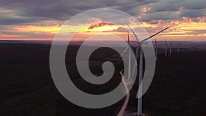 Close up Wind turbine farm on beautiful purple evening mountain landscape. Renewable energy production for green