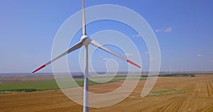 Close up of a wind turbine spinning over farmers fields. Energy Farm