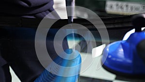 Close-up of the windshield repair process in a car service. Master applies glue.