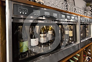 Close up of wine bottles in dispenser at bar