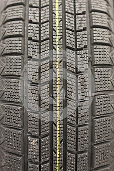 Close-up winter tire tread. Textured tire tread. Part of brand new modern winter car tire. vertical photo