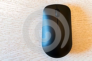 Close up of wireless computer mouse on white wooden background