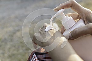 Close up woman applying cream on her hands to moisturize the skin