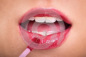 Close up of woman applying lipstick
