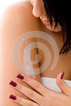 Close up of woman applying lotion on her arm