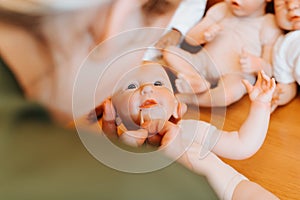 Close-up woman artist decorating cute realistic caucasian newborn baby doll with painting brush, lips design.