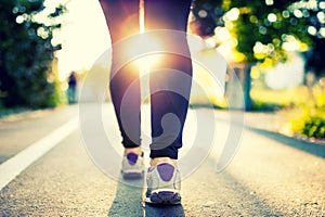 Close-up of woman athlete feet and shoes while running in park