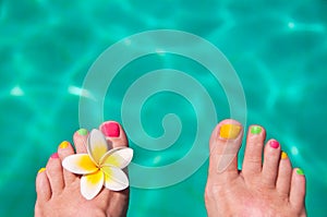 Close up on woman bare foot, turquoise swimming pool