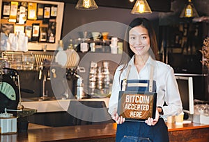 Close up woman barista holding tablet and show bitcoin accepted