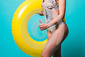 Close up woman in bikini with inflatable ring isolated on green background
