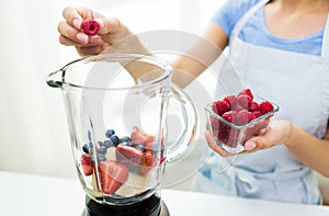 Close up of woman with blender making fruit shake