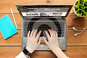 Close up of woman blogging on laptop