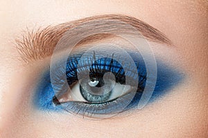 Close-up of woman blue eye with beautiful blue smokey eyes makeup