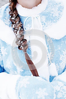 Close-up of woman braided hair in snow, girl in traditional russian suit of snow maiden