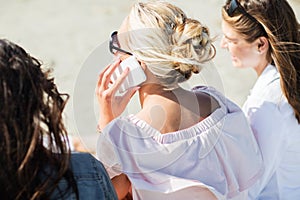 Close up of woman calling by smartphone on beach