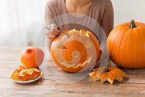 Close up of woman carving halloween pumpkin