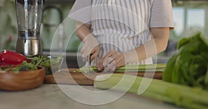 Close up of a woman chopping vegetables in a kitchen