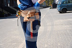 Close-up woman civil engineer with worktool belt controlling building work